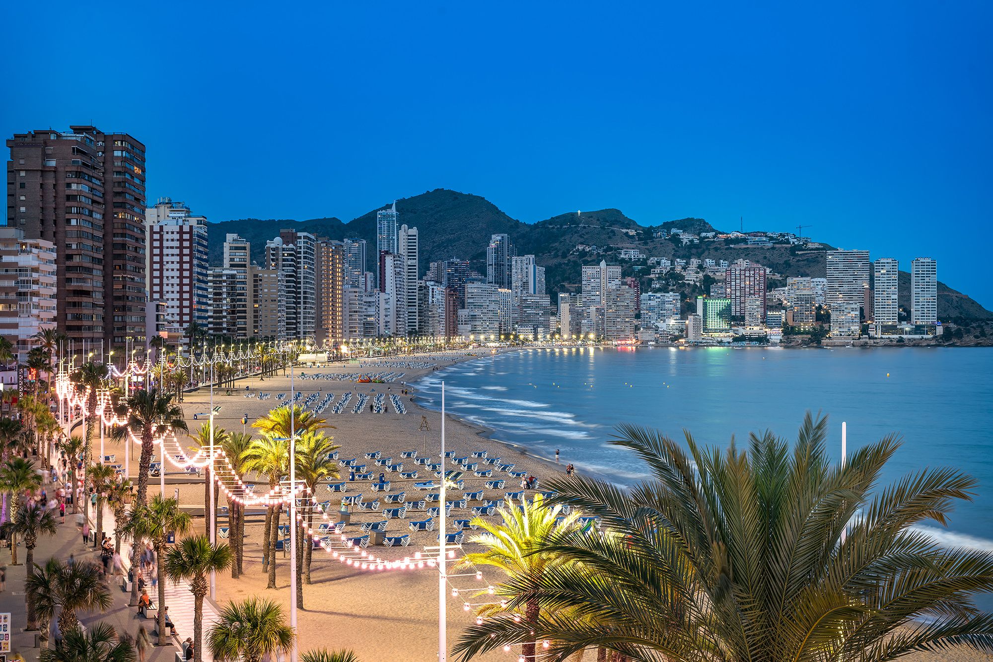 Benidorm beach with a city skyline and ocean behind, highlighting a lively urban and seaside landscape.