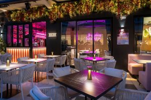 Baldo Restaurant and Bar on the beach, showcasing tables and chairs set up for guests to enjoy the ocean view.