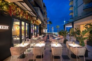 Beachfront Baldo Restaurant and Bar featuring outdoor tables and chairs, perfect for dining by the sea.