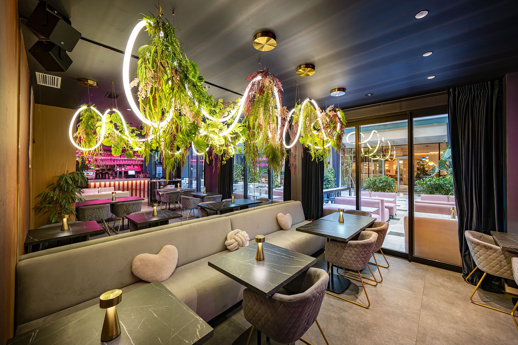 Restaurant interior of baldo restaurant featuring purple walls and a large, stylish hanging light fixture.