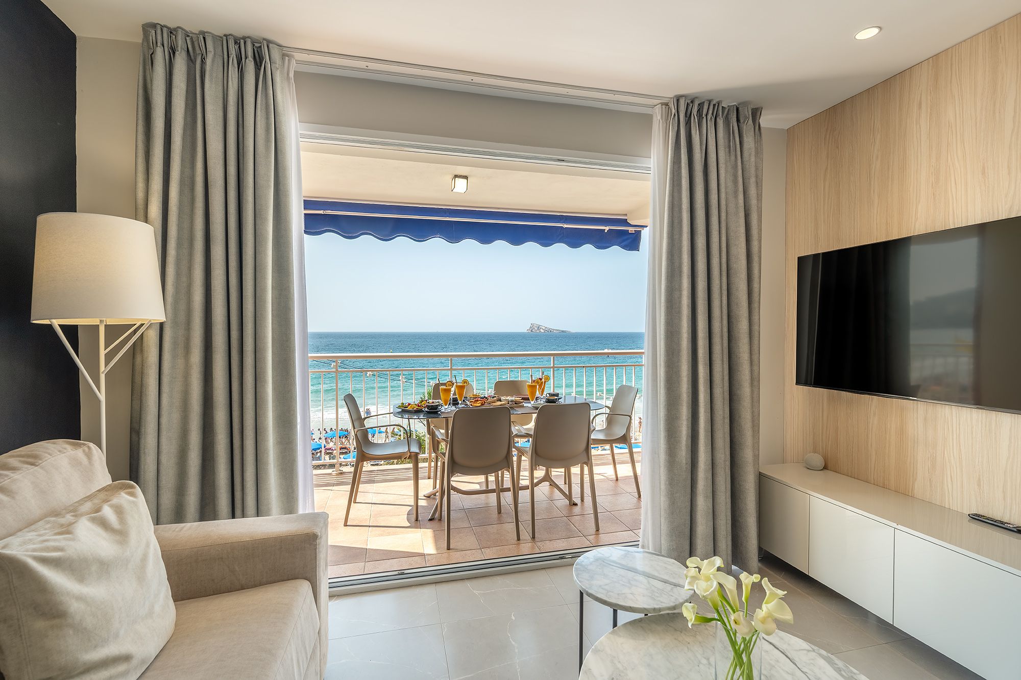 Living room of Mara boutique apartment with a TV and beautiful ocean scenery.