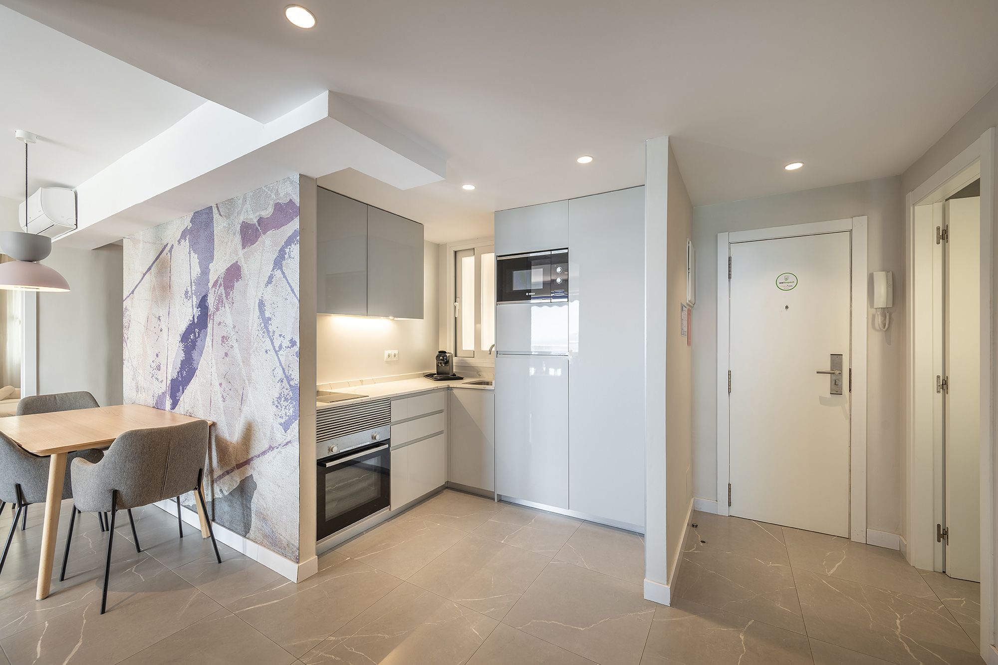 A bright kitchen with a dining table and four chairs set up for meals.