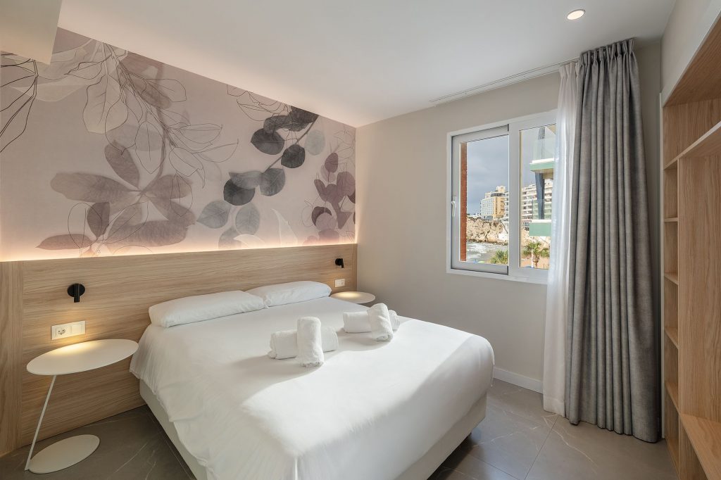 Stylish aparthotel room in Mara boutique apartment with a comfortable bed and an artistic wall mural.