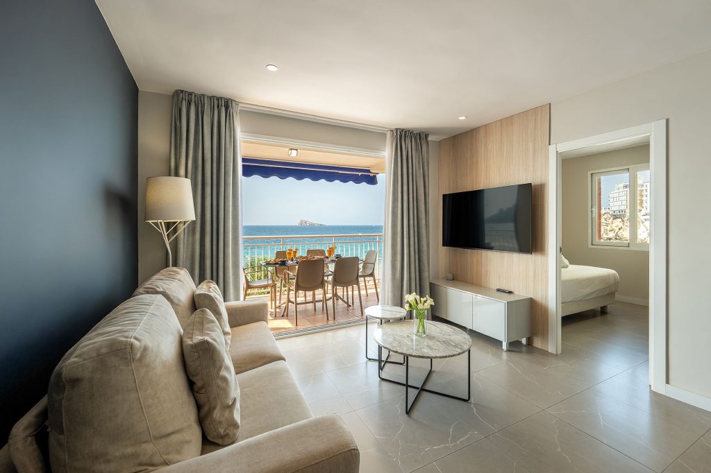 The living room of the Mara Boutique Apartment, showcasing a beautiful ocean view through expansive windows.