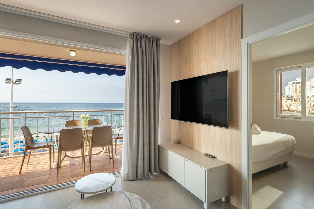 The living room of the Mara Boutique Apartment, showcasing a beautiful ocean view through expansive windows.