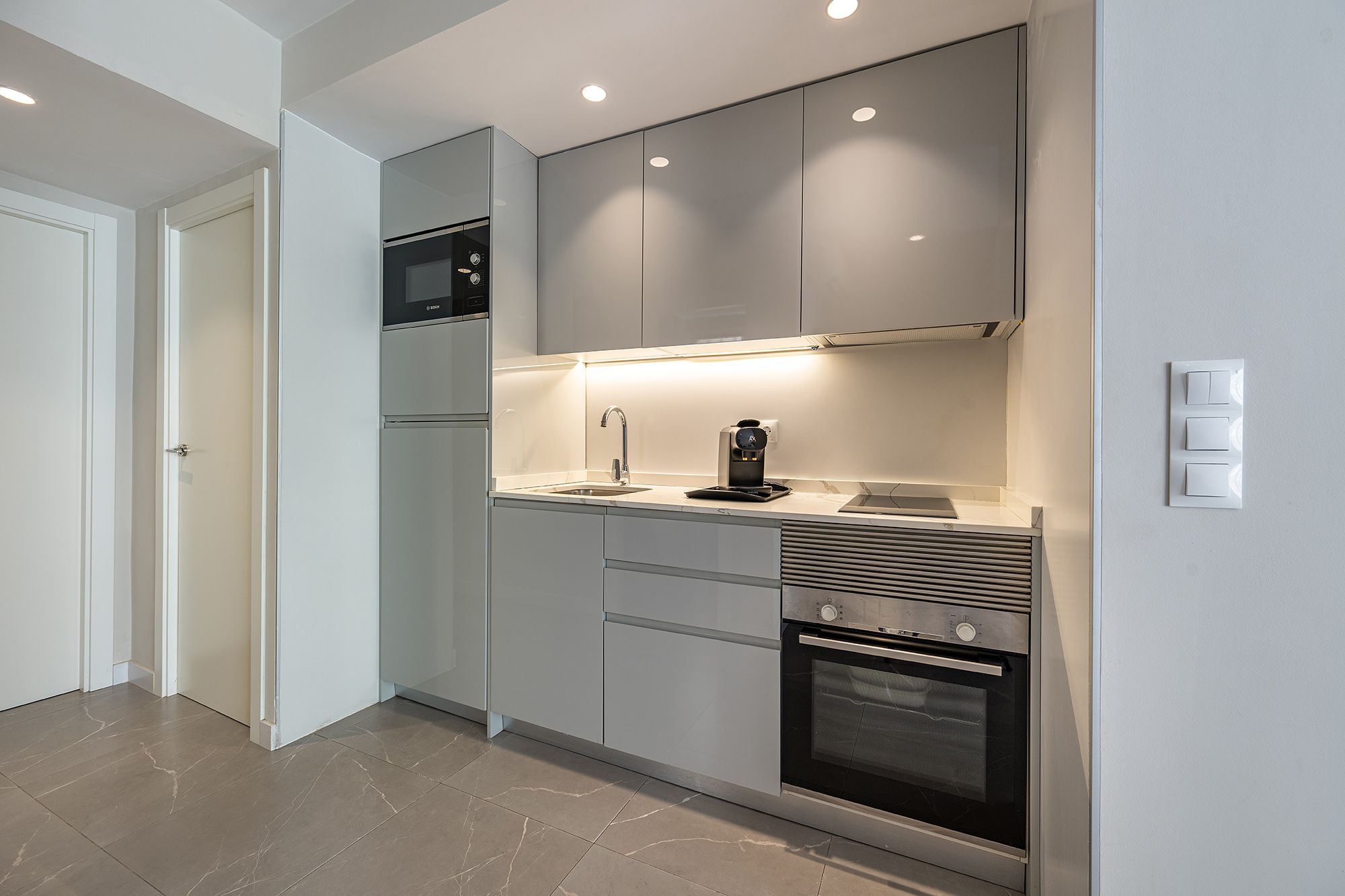 Una pequeña y encantadora cocina con fregadero, microondas y horno, que ofrece un ambiente cálido para preparar las comidas.