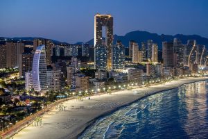 Stunning night scene of Benidorm, featuring the beach and city skyline illuminated against the sea.