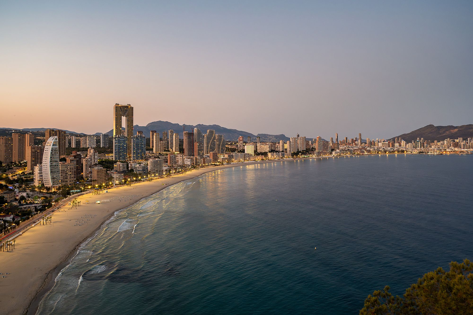 Benidorm beach with a city skyline and ocean behind, highlighting a lively urban and seaside landscape.