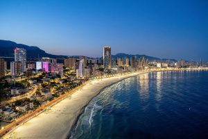 Benidorm beach with a city skyline and ocean behind, highlighting a lively urban and seaside landscape.