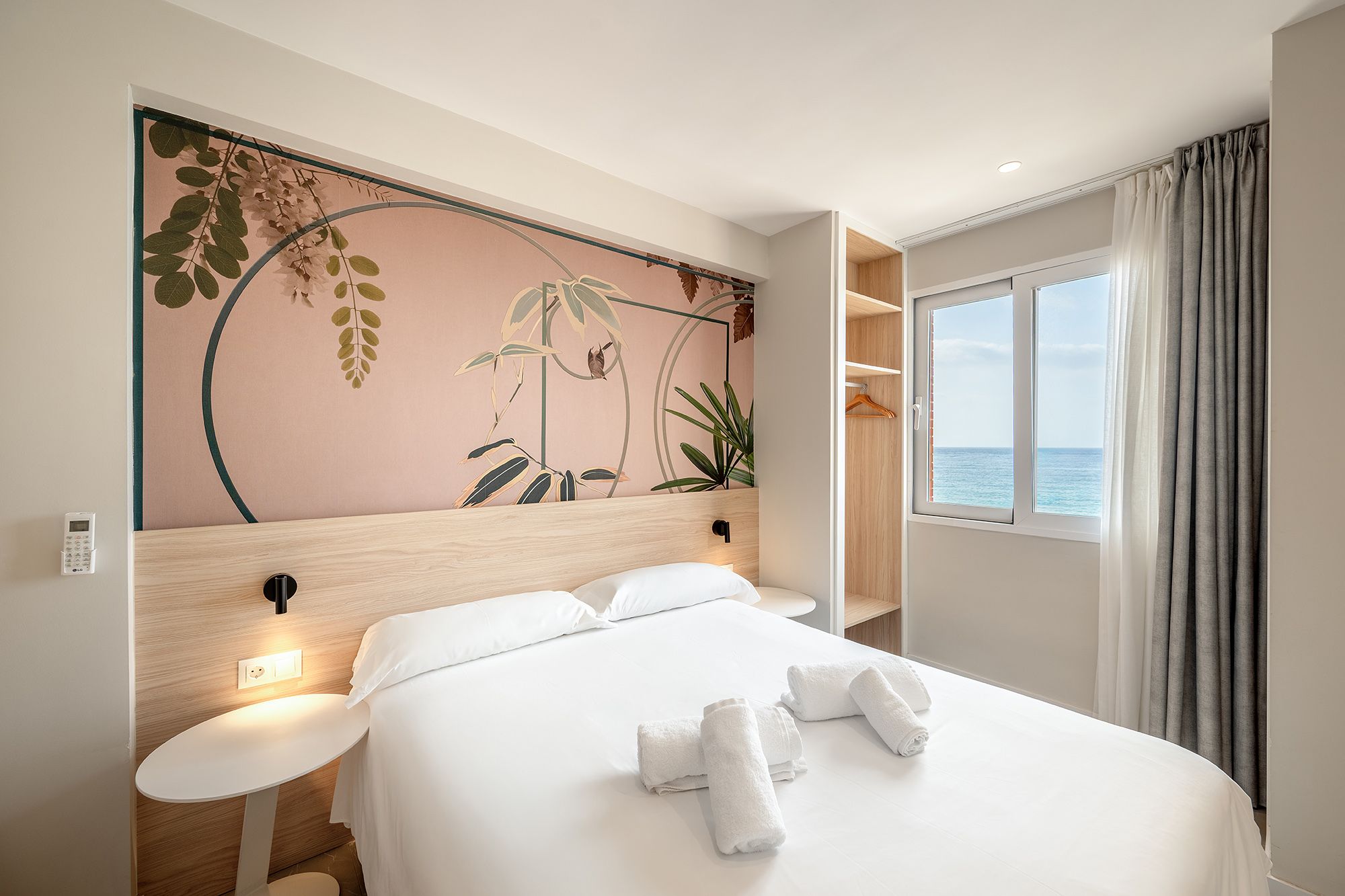 Elegante habitación de apartahotel en el apartamento boutique Mara, con una cómoda cama y un artístico mural en la pared.