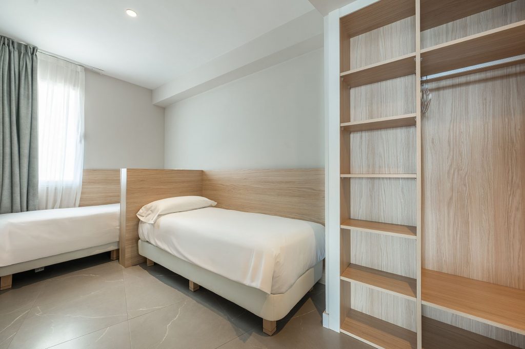 Luminosa y acogedora habitación de apartahotel en la boutique Mara, con camas individuales cercanas entre sí.