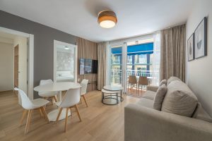 A sleek modern apartment featuring a stylish dining table surrounded by chairs.