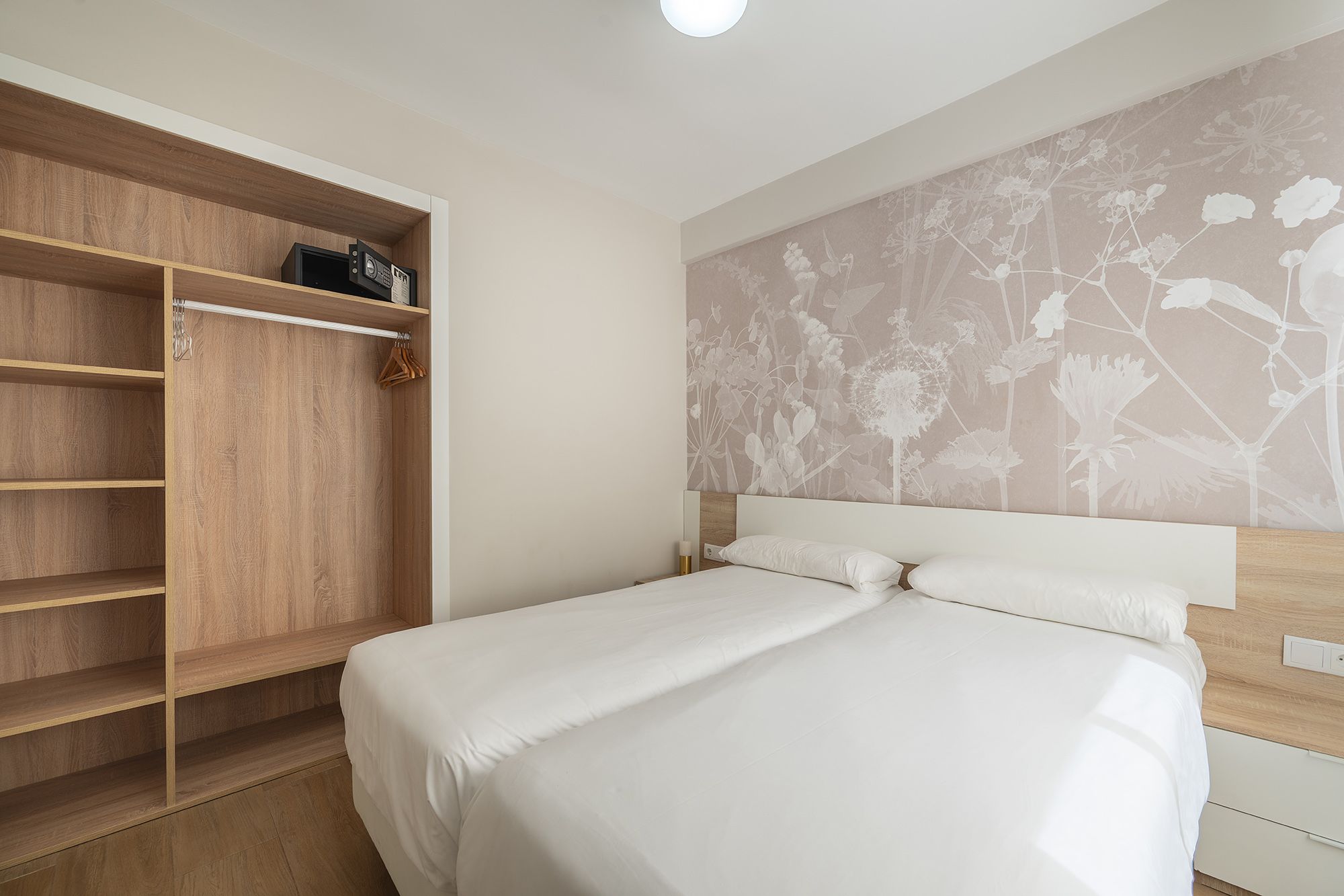 Un dormitorio bien organizado, con una cama cómoda y un armario, que crea un espacio vital sereno.