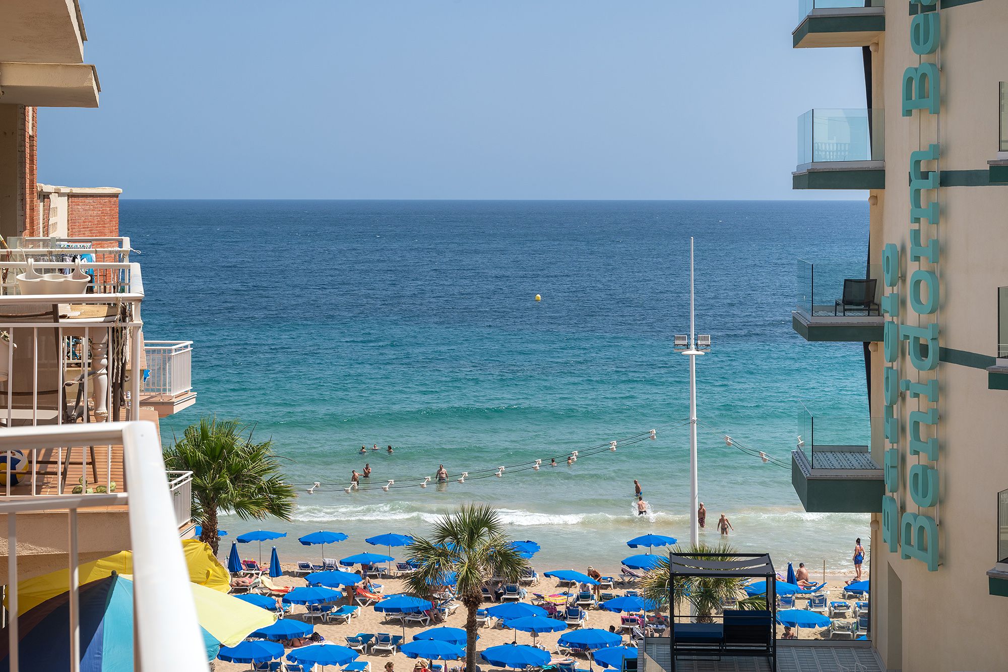 Balcony view of Benidorm's beach and cliffs, highlighting the picturesque landscape and vibrant blue waters.