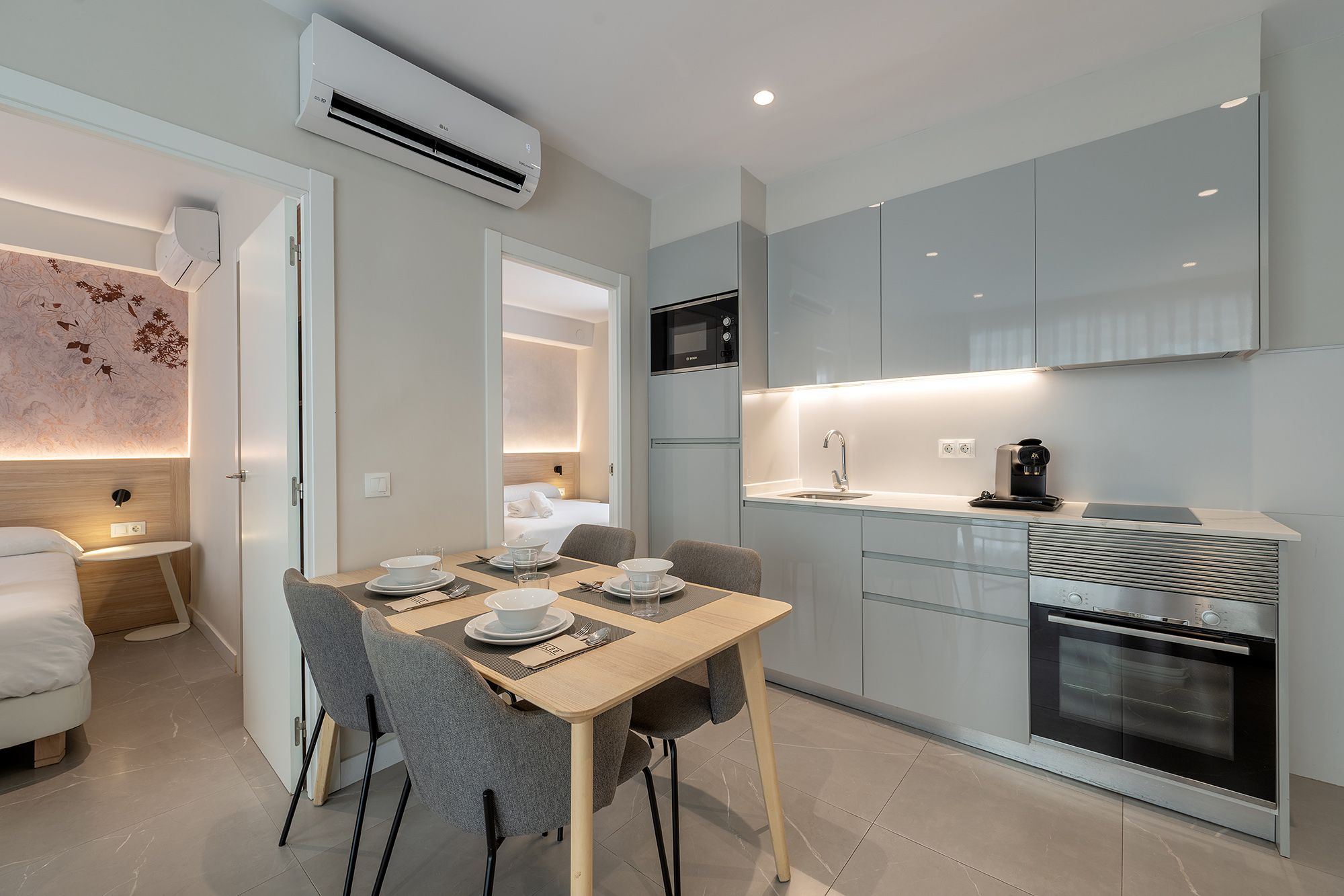 A stylish small kitchen and dining area in a modern apartment, highlighting efficient use of space and modern furnishings.