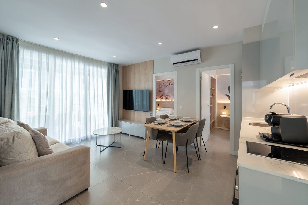 Interior view of a contemporary apartment showcasing a kitchen, living room, and dining space.