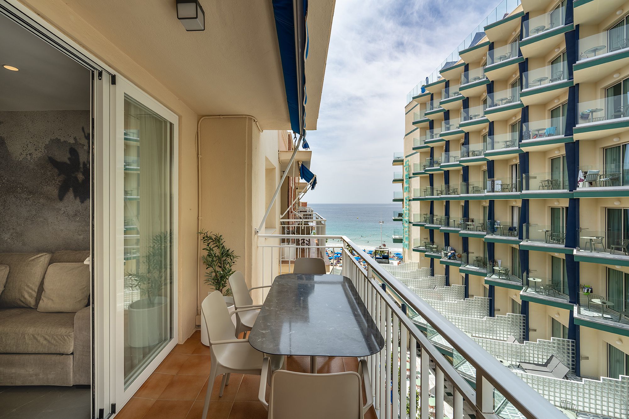 A serene balcony with a table and chairs, providing a picturesque view of the ocean horizon.