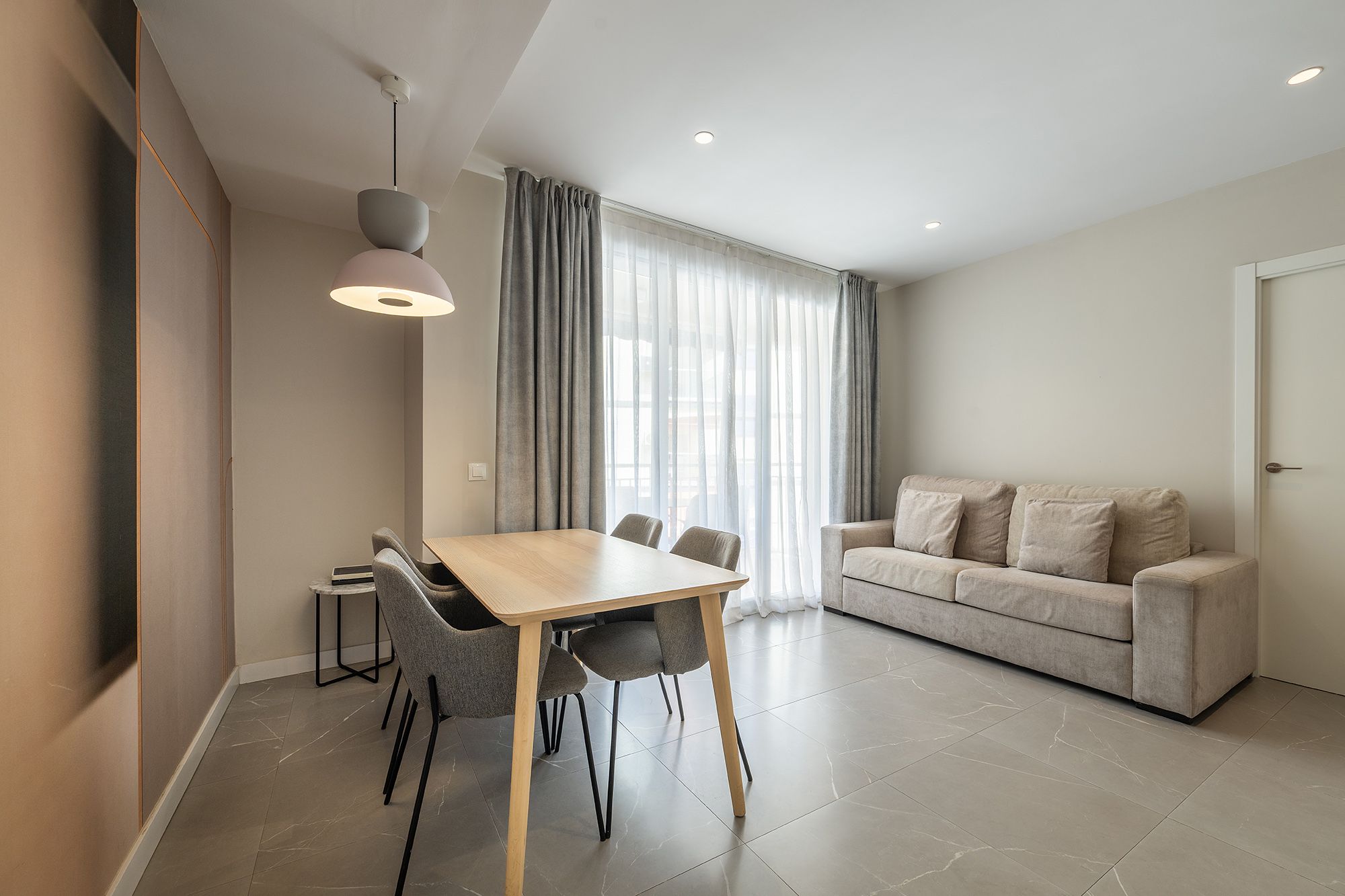 Contemporary apartment interior showcasing a dining area with a table and chairs.