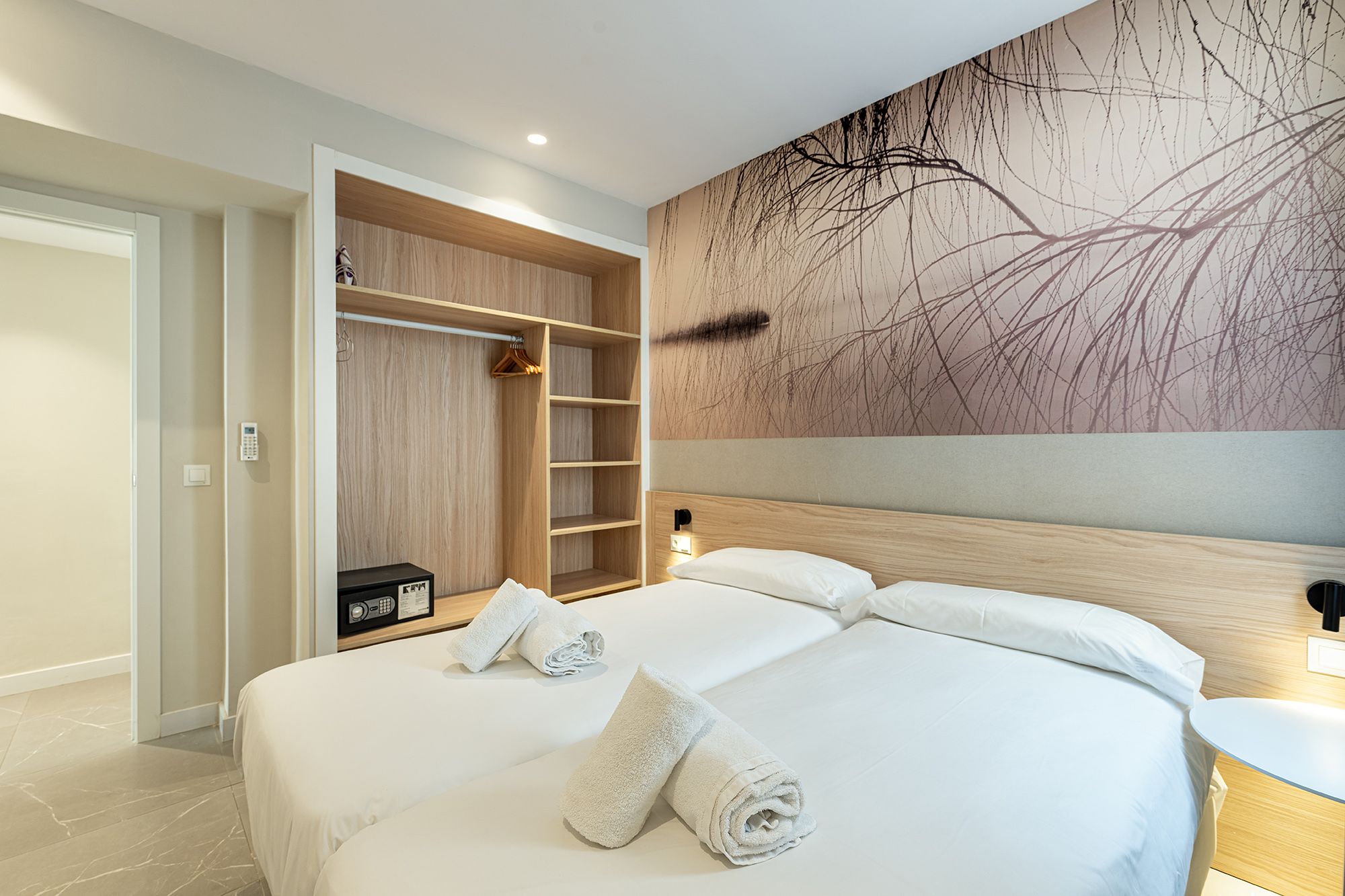 Un acogedor dormitorio con dos camas y un colorido cuadro en la pared, que crea un ambiente acogedor para las estancias turísticas en Benidorm