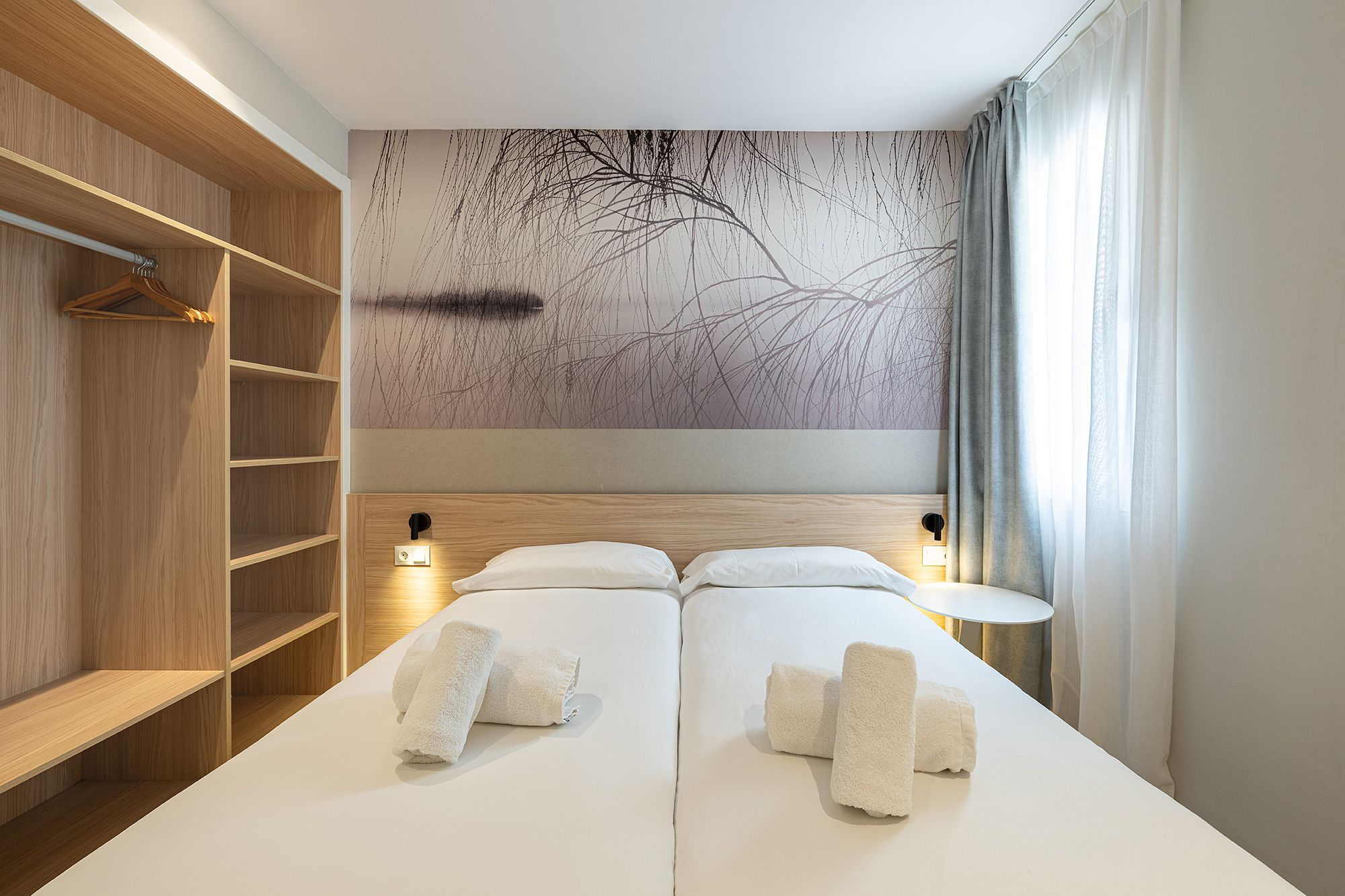 Un acogedor dormitorio con dos camas y un colorido cuadro en la pared, que crea un ambiente acogedor.