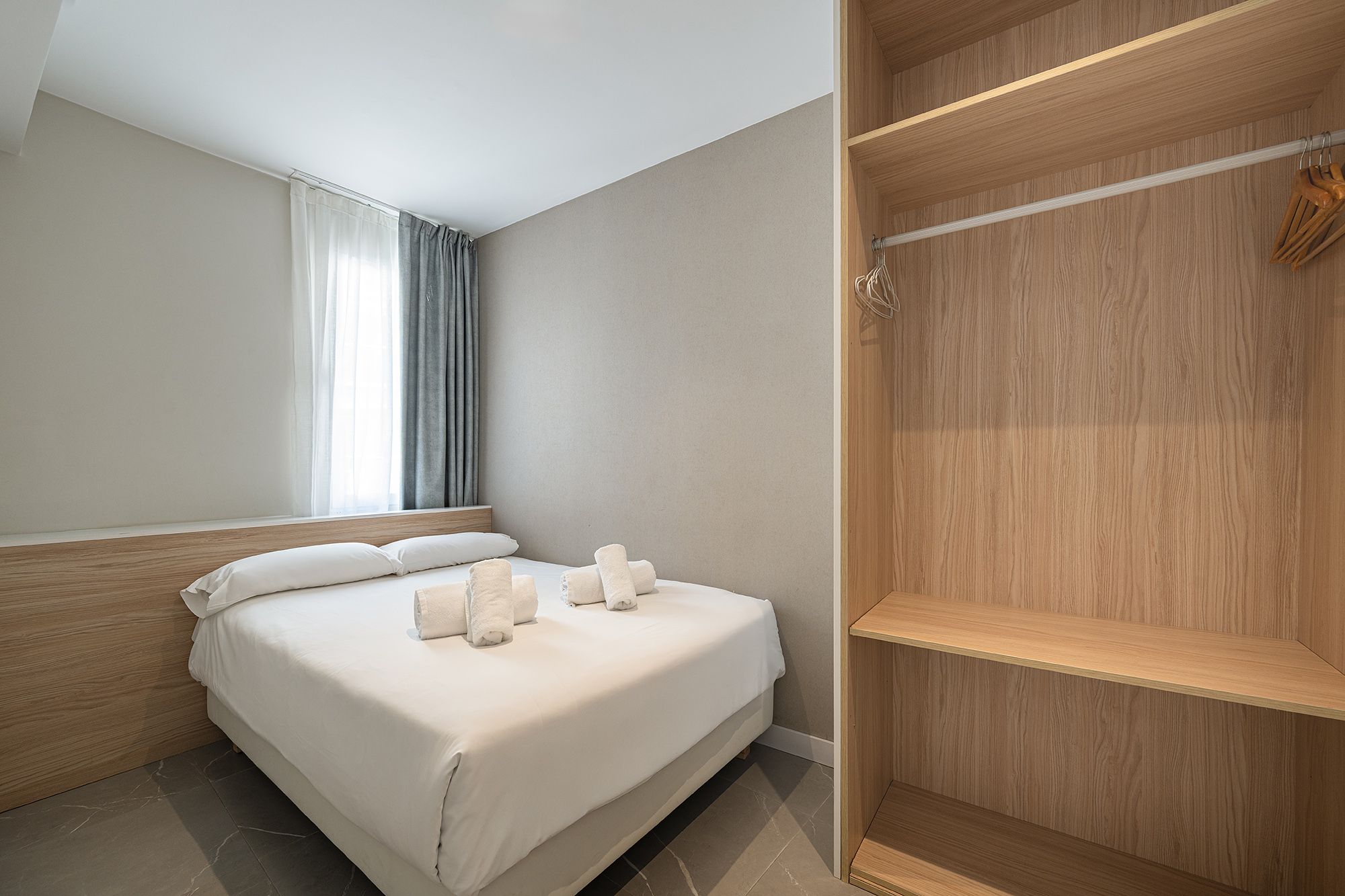 Un dormitorio compacto con una cama individual y un armario, creando un espacio sencillo y funcional.