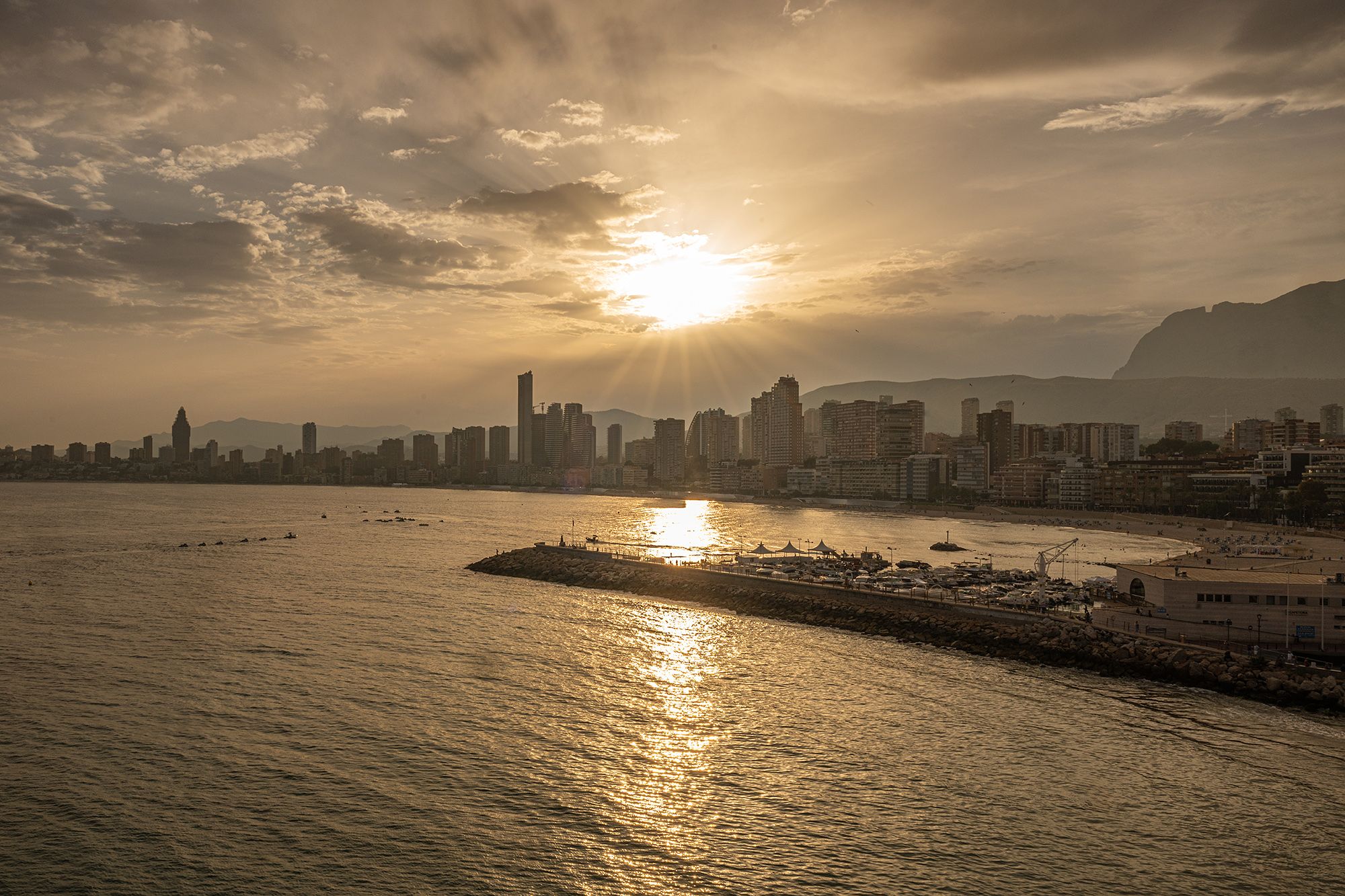 A scenic view of a city skyline with a peaceful water surface in front, highlighting urban architecture.