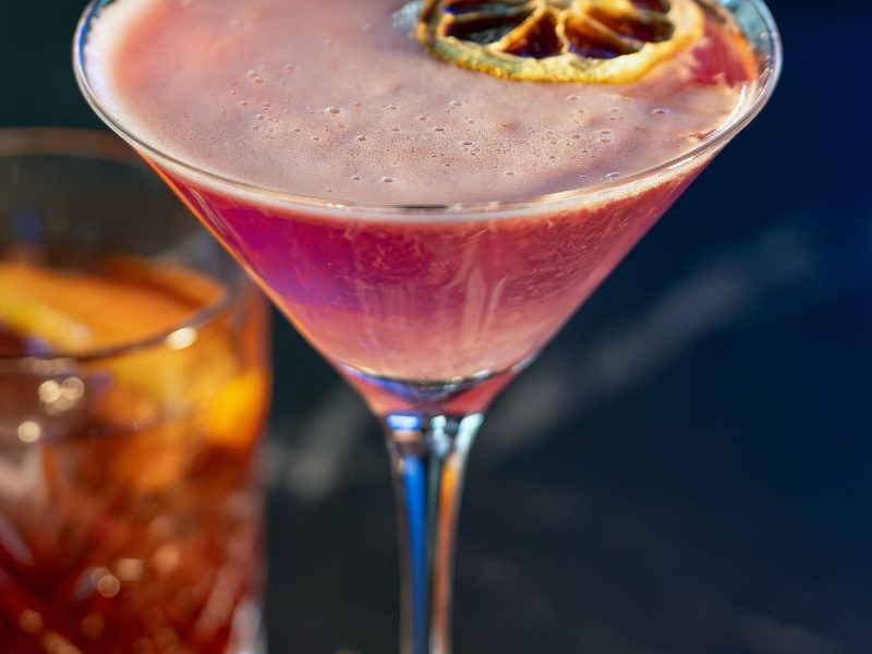 A delightful cocktail topped with a bright orange slice, perfect for a sunny day.