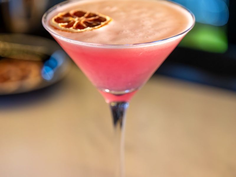 A delightful cocktail topped with a bright orange slice, perfect for a sunny day.