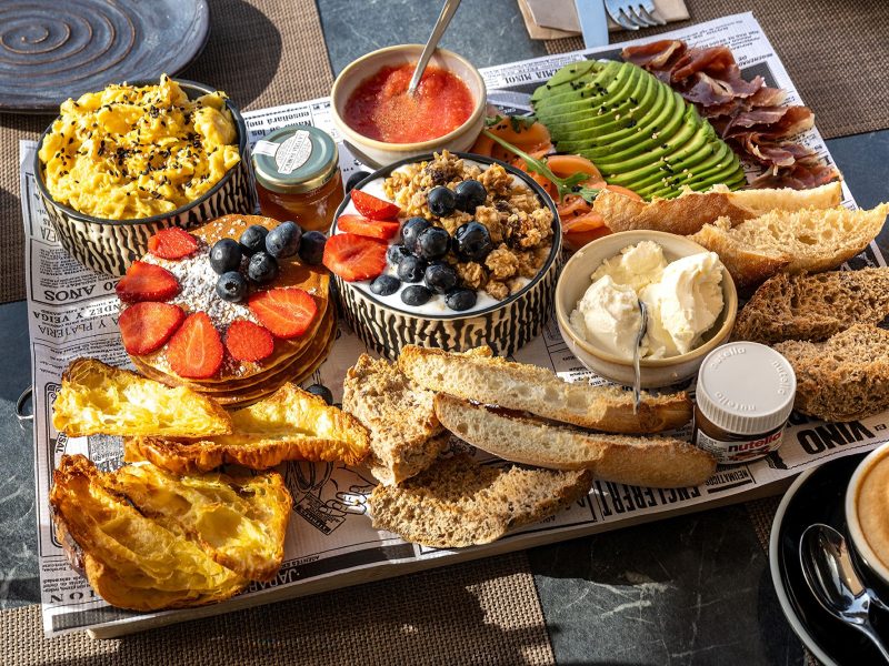 A tempting tray of food on a table, with a warm cup of coffee and a charming cup of tea ready to enjoy.