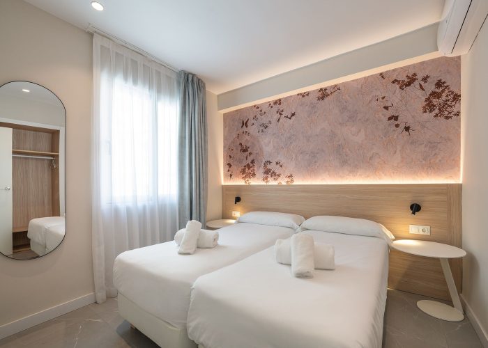 Stylish bedroom showcasing a white bed and wall mural. Two individual bed united to make a double bed for guests