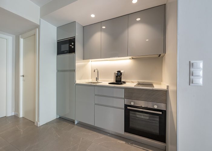 A charming small kitchen with a sink, microwave, and oven, offering a warm atmosphere for meal preparation.