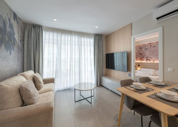 Elegante interior de apartamento con una mesa de comedor y un sofá, destacando una estética moderna.