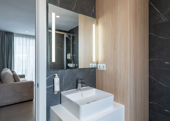 A minimalist bathroom scene with a contemporary sink and a mirror, highlighting simplicity and elegance.